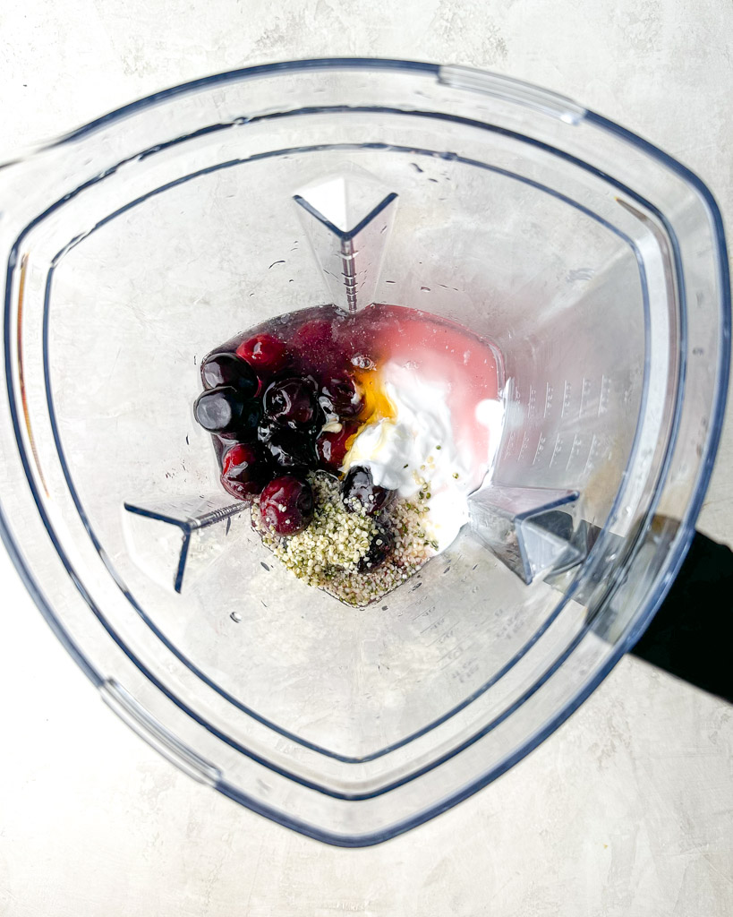 overhead view of cherry smoothie ingredients in a blender