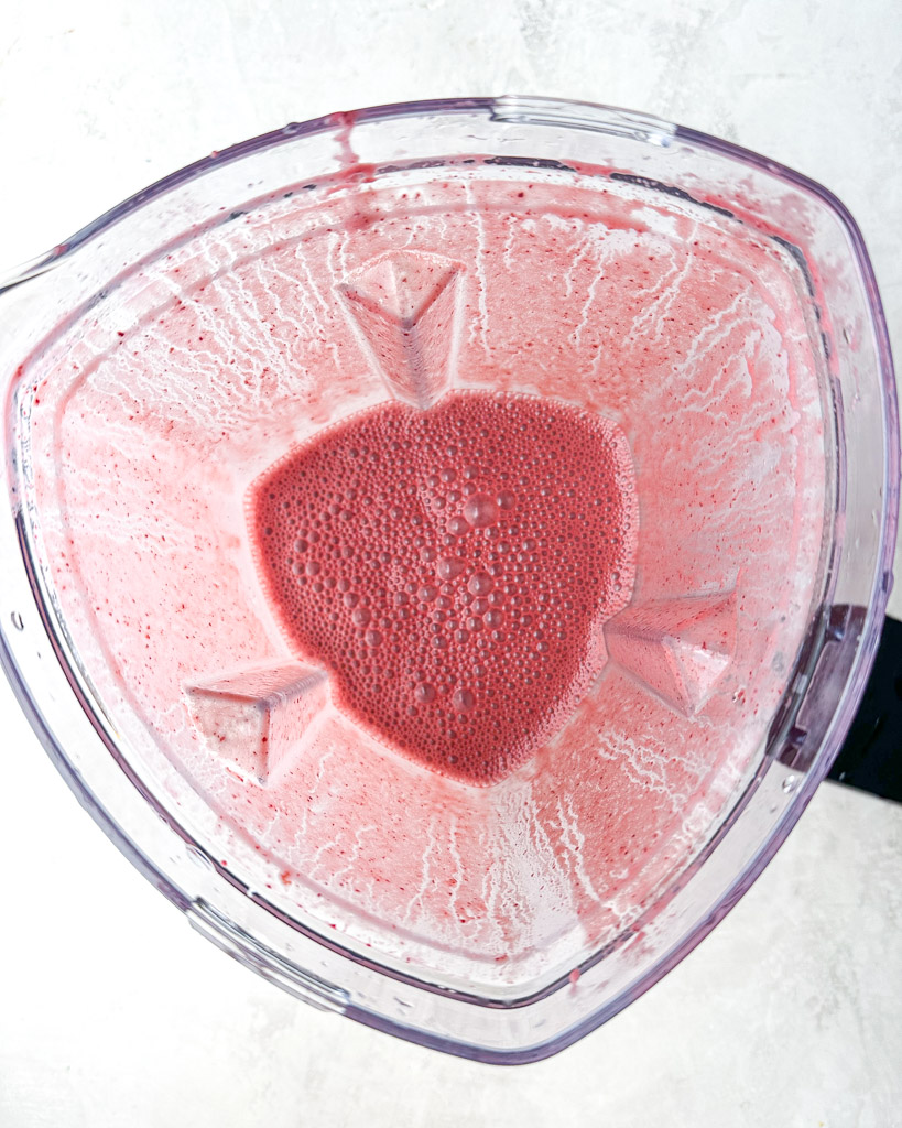 overhead view of blended cherry smoothie in a blender