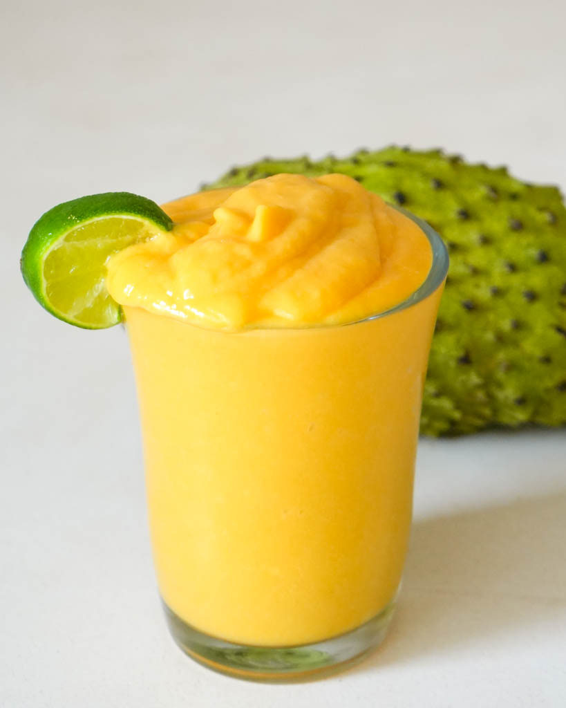 soursop smoothie in a glass garnished with lime