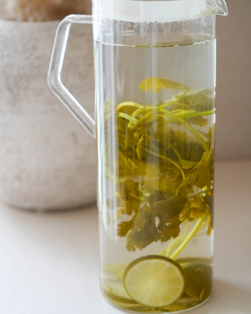 cilantro steeped in a large glass pitcher